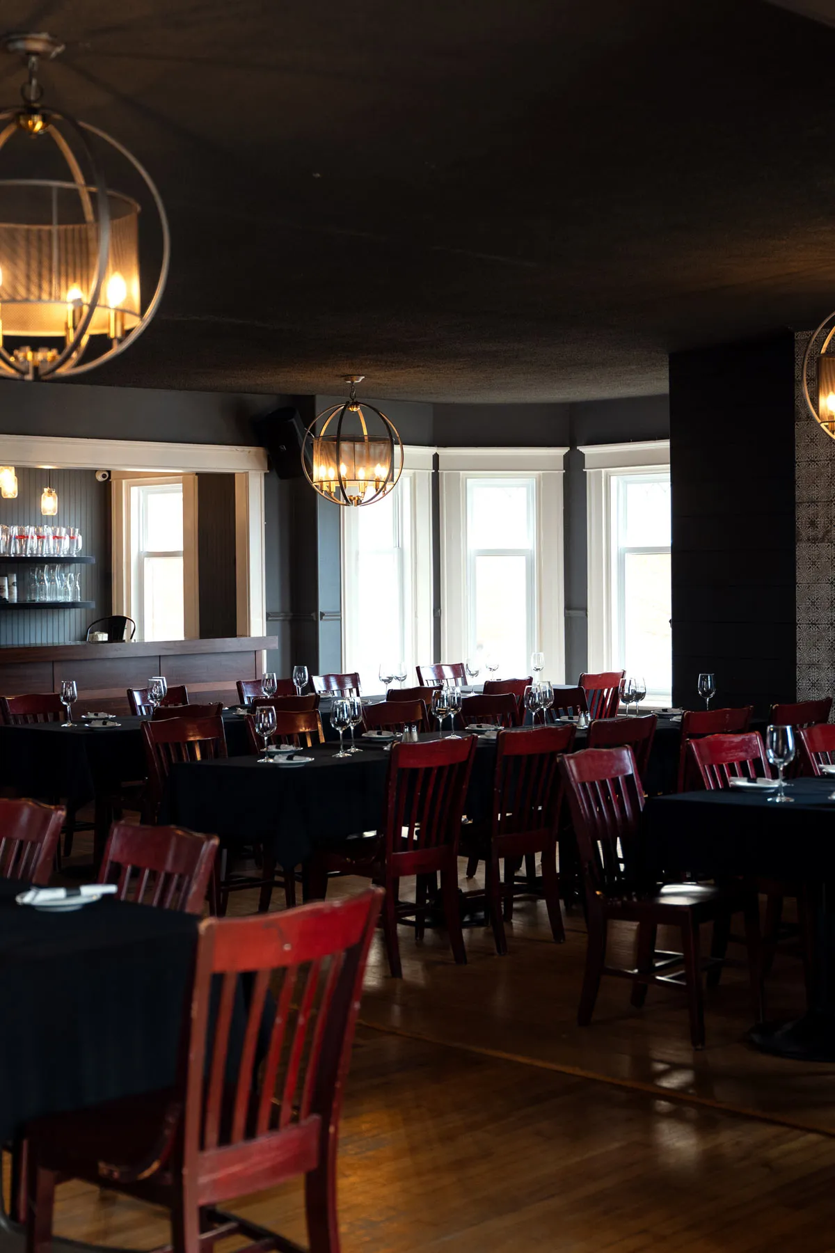 La salle du McBroue prête pour un groupe, tables dressées sous les lustres